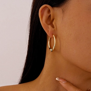 Close-up of minimalist golden irregular geometric earrings worn by a model