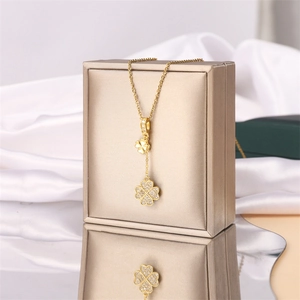 Élégant collier en acier titane doré avec pendentifs double trèfle et zircons blancs