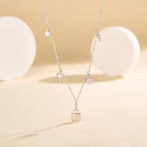 Close-up of S925 silver necklace with key, lock pendants and zircon tassels