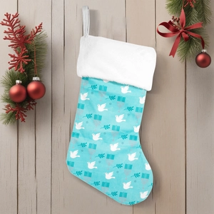 Blue Christmas stocking with white dove and candle pattern on rustic wood backdrop
