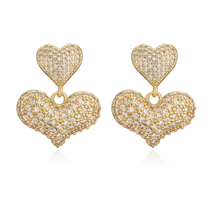 Orecchini a cuore placcati in oro con pavé di zirconi su sfondo bianco puro