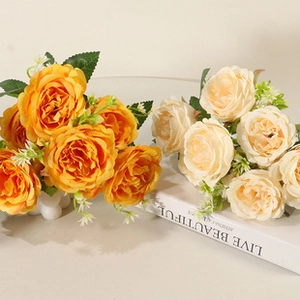 Close-up of artificial cherry blossom silk flowers in orange and champagne hues