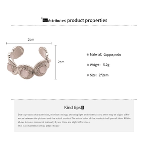 Détail de la bague ajustable en laiton avec fleur en résine rose et gravure texturée