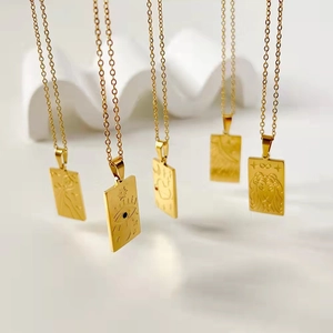 Set aus fünf goldenen Tarot-Quadrat-Anhängern aus Edelstahl hängend auf weißem Display