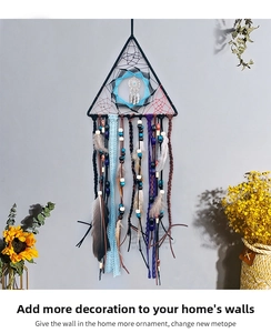 Detail of bohemian triangle dream catcher with feathers and wood beads on gray wall