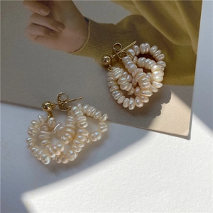 Detail of woven freshwater pearl hoop earrings with elegant gold metal craftsmanship