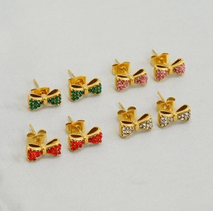 Vue détaillée de quatre paires de boucles d'oreilles nœuds dorées avec strass colorés