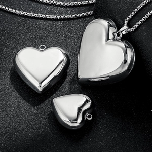 Polished silver heart pendants in three sizes on a premium black textured surface