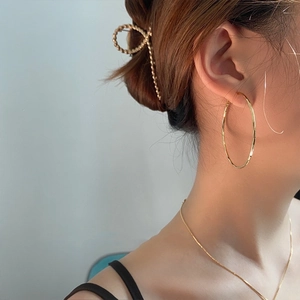 Detail of large gold hoop earrings and matching necklace set on female model