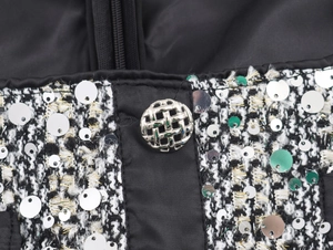 Detail of tweed dress with sequins and a silver textured button close-up