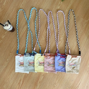 Detail of colorful woven rope straps and carousel embroidery on mini oxford cloth bags