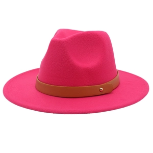 Détail d'un chapeau fedora en feutre rose vif avec ceinture en cuir marron et rivet doré