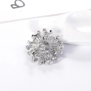 Silver geometric snowflake brooch with radial design and safety pin clasp on white background
