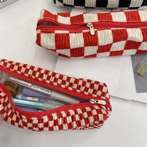 Close-up of red and white checkerboard stationery bag with 3D pleated texture and silver zipper