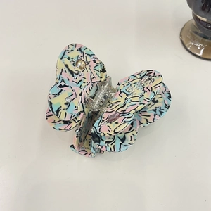 Detailed macro view of an elegant acetate butterfly hair claw clip with colorful patterns