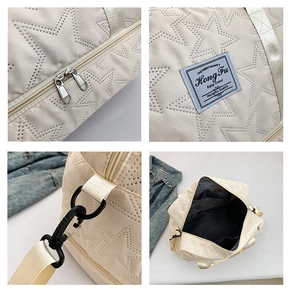 Detail view of the embossed star pattern and durable metal zipper on the beige travel bag