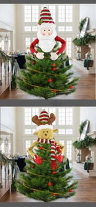 Detail of plush Santa and Reindeer tree toppers with long arms on a Christmas tree