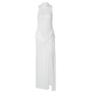 Detail of white sleeveless high-neck maxi dress featuring waist pleats and a side slit