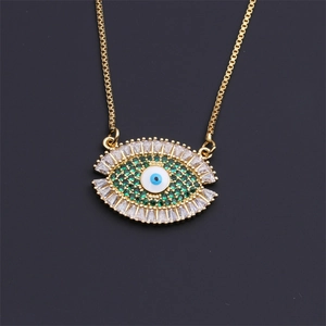 Macro view of gold plated Evil Eye pendant with green and clear zircon stones