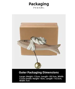 Macro detail of hand-carved wooden fish pendant with a gold bell in a gift box