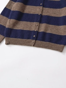 Detail showing dark blue and brown stripes on fine knit fabric with fabric-covered buttons