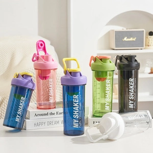 Multiple colors of fitness protein shaker bottles with mixing balls on a desk