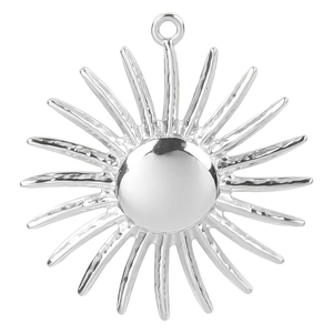 Macro detail of silver sunburst pendant with polished center sphere and radiant rays