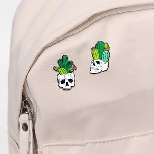 Punk enamel skull cactus pins on a cream backpack featuring gothic skull and green cactus