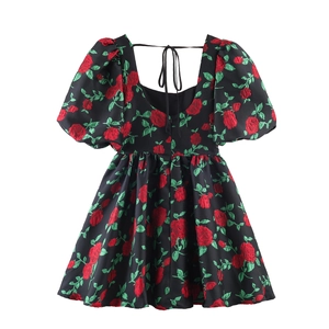 Vue arrière d'une mini robe noire à manches bouffantes, jacquard rose et dos nu à nouer