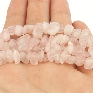 Macro detail of natural rose quartz stone chips held in hand for DIY jewelry making