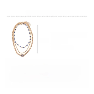 Detailed view of layered gold necklace with blue evil eye charms and rhinestone accents