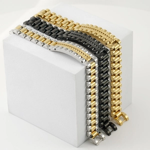 Three-color stainless steel watch bands in gold, black, and silver displayed on pedestals