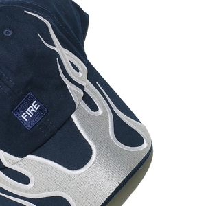 Close-up of premium silver flame embroidery and FIRE patch on navy blue cotton cap