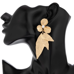 Detailed close-up of a gold ginkgo leaf flower earring with a pearl on a black model