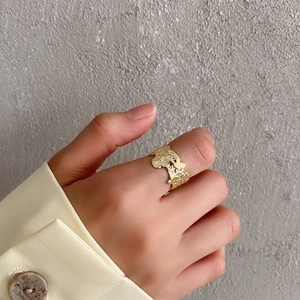 Detailed view of the irregular molten texture gold S925 sterling silver ring on a finger