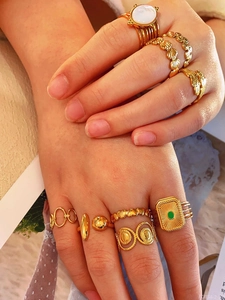 Close-up of golden vintage rings set including green gemstone and engraved textures