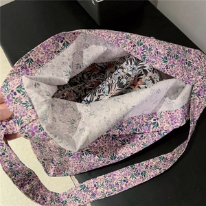 Detailed interior view of floral cotton tote bag with purple prints and wide straps