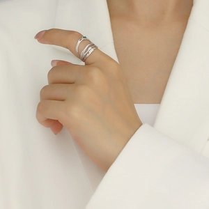 Minimalist silver-toned layered rings with green gemstone on professional model hand
