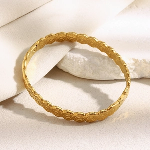 Dettaglio macro del bracciale a fiori placcato oro 18 carati con trama a rosa in rilievo