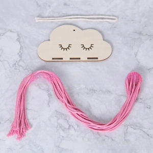 Close-up of DIY cloud hair clip holder with pink cotton cord and wooden cloud base