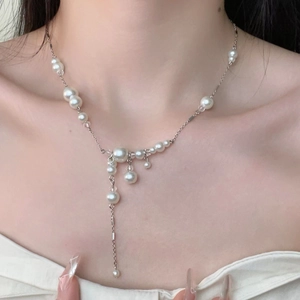Detailed view of elegant pearl tassel necklace on model highlighting silver chain texture