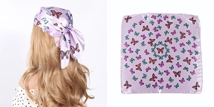 Detail of lavender butterfly silk scarf tied as a headband on blonde hair and flat layout