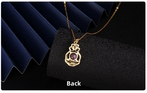 Macro back view of gold necklace pendant with purple zircon and intricate hollow metalwork