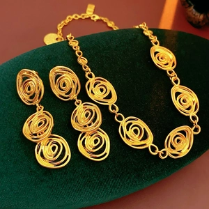 Close-up of gold vintage floral jewelry set with spiral patterns on green velvet