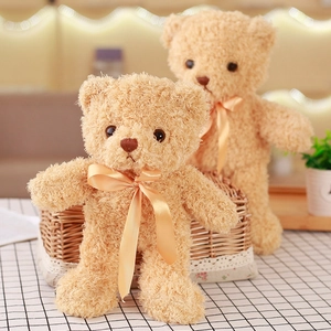 Close-up of small light brown teddy bear skin shell with elegant satin bow tie
