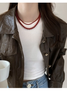 Détail du collier à double rang de perles rouge foncé montrant les tailles des perles