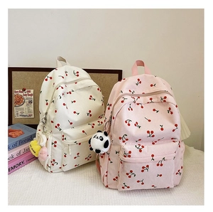 Detail of corduroy cherry backpacks in cream and pink with cute panda pendants