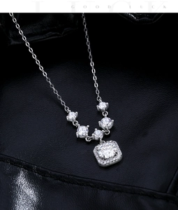 Macro shot of 925 sterling silver square halo pendant with moissanite on black leather
