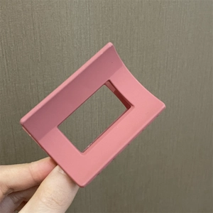Detalle de pinza cuadrada hueca rosa para el cabello para peinados elegantes en mano