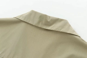 Detailed close-up showing the collar stitching and woven fabric of the khaki poplin shirt